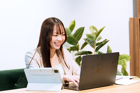 ノートパソコンを操作する女性のビジネスパーソン